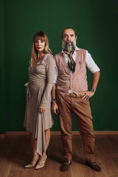istock Mature couple posing for a portrait against a green wall 1347299561
