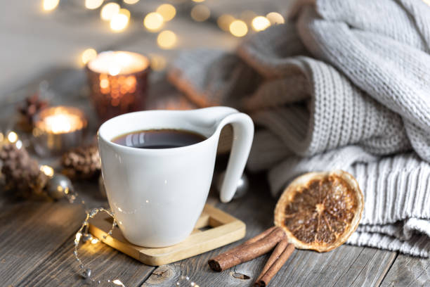 istock Cup of tea on a blurred background with candles, knitted sweaters, and bokeh. 1347299685