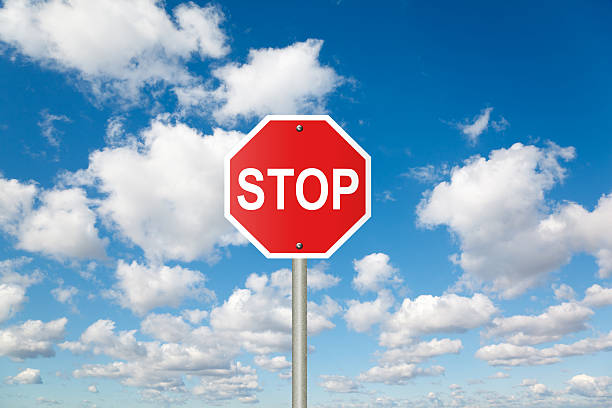 Stop sign on white, fluffy clouds in blue sky collage