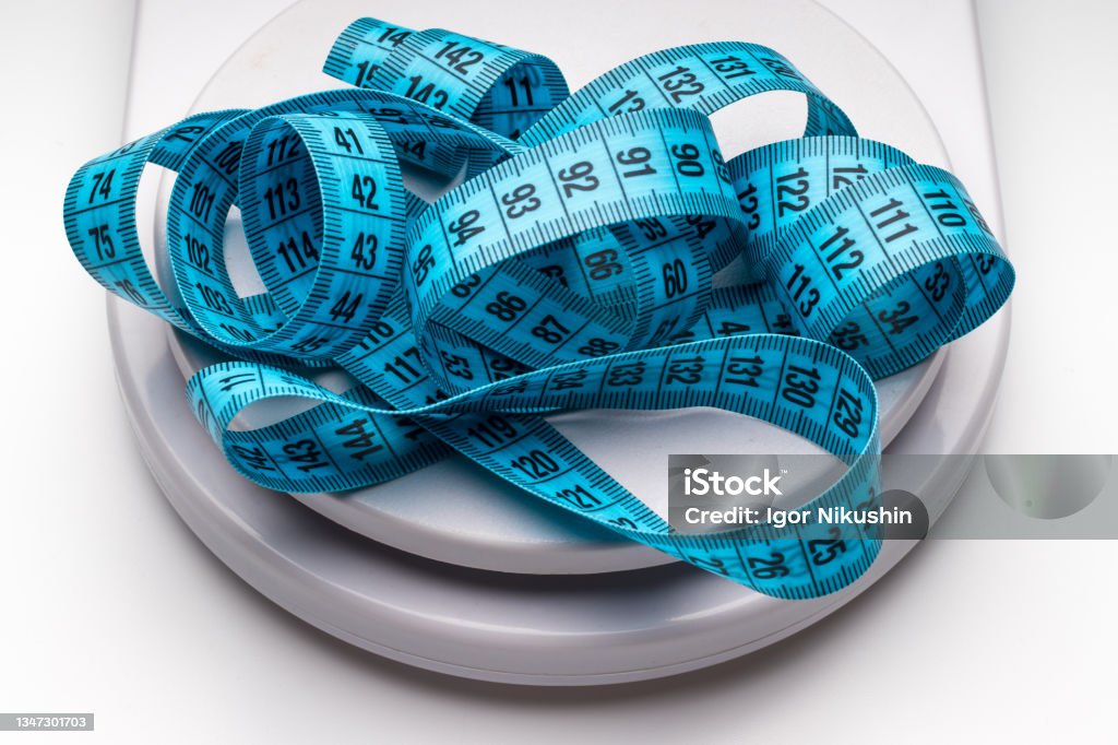 Blue measuring tape and weight scales. Obesity Stock Photo