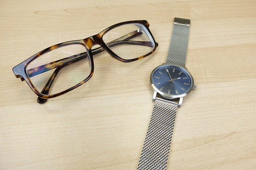 Spotted eyeglasses and steel watch