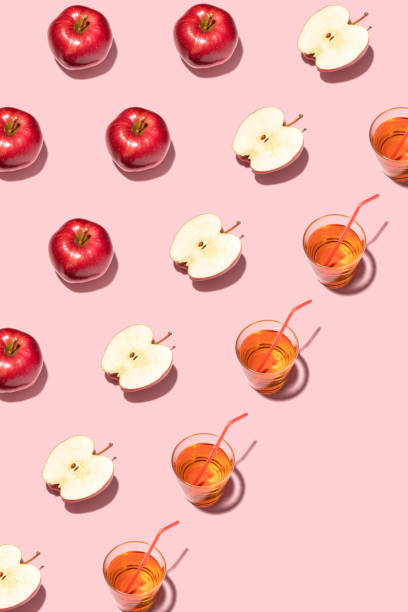 istock Red apples and juice on pink background. Pattern, top view, flat lay. 1347304622