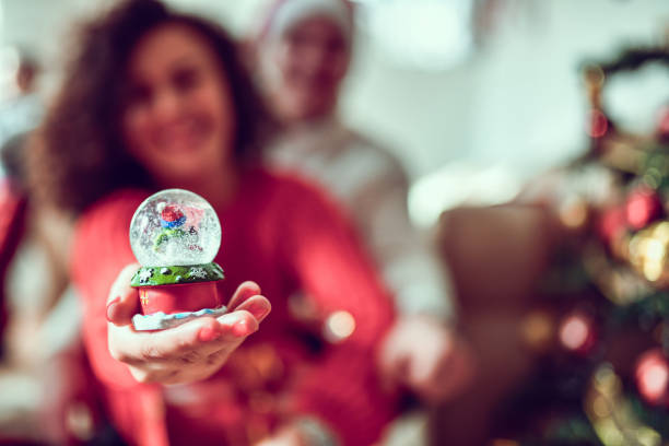 A Christmas ornament featuring a gift, surrounded by festive lights and decorations. 3d rendering