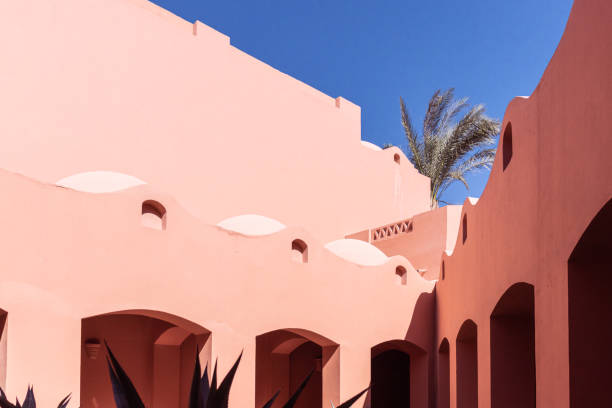 istock Orange hotel building with many arches in bright sunlight with contrasting shadows 1347305856