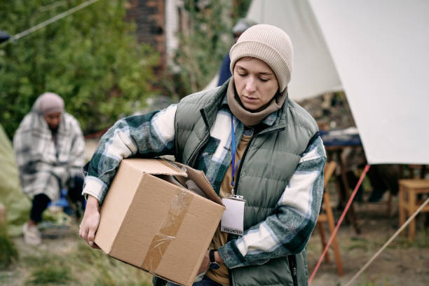 istock Young woman carrying box with clothes for refugees 1347306085