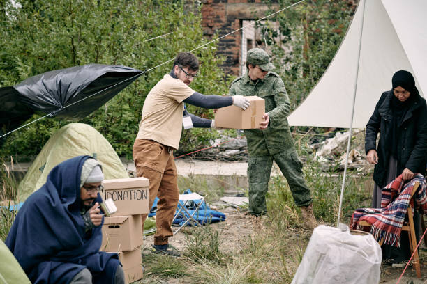 istock Young volunteer and representative of migration service spreading donation 1347306123