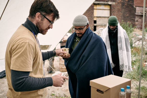 Male volunteer working in donation tent while giving humanitarian help to migrants