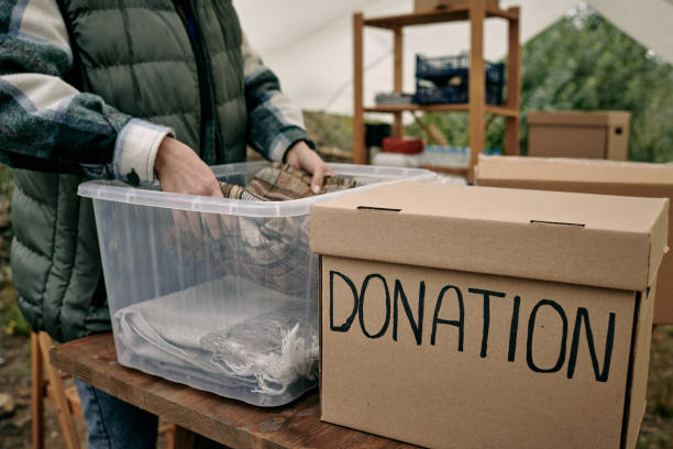 istock Female volunteer putting folded clothes into container 1347306261