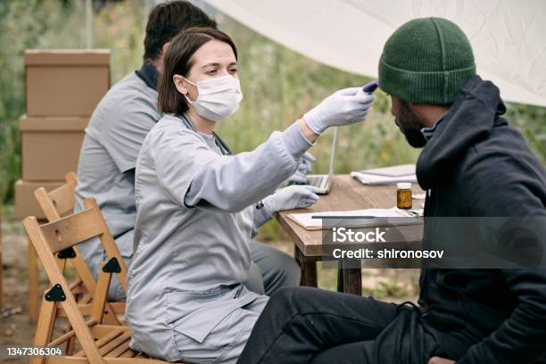 Doctor In Protective Mask Measuring Body Temperature Of Sick Man Stock Photo - Download Image Now