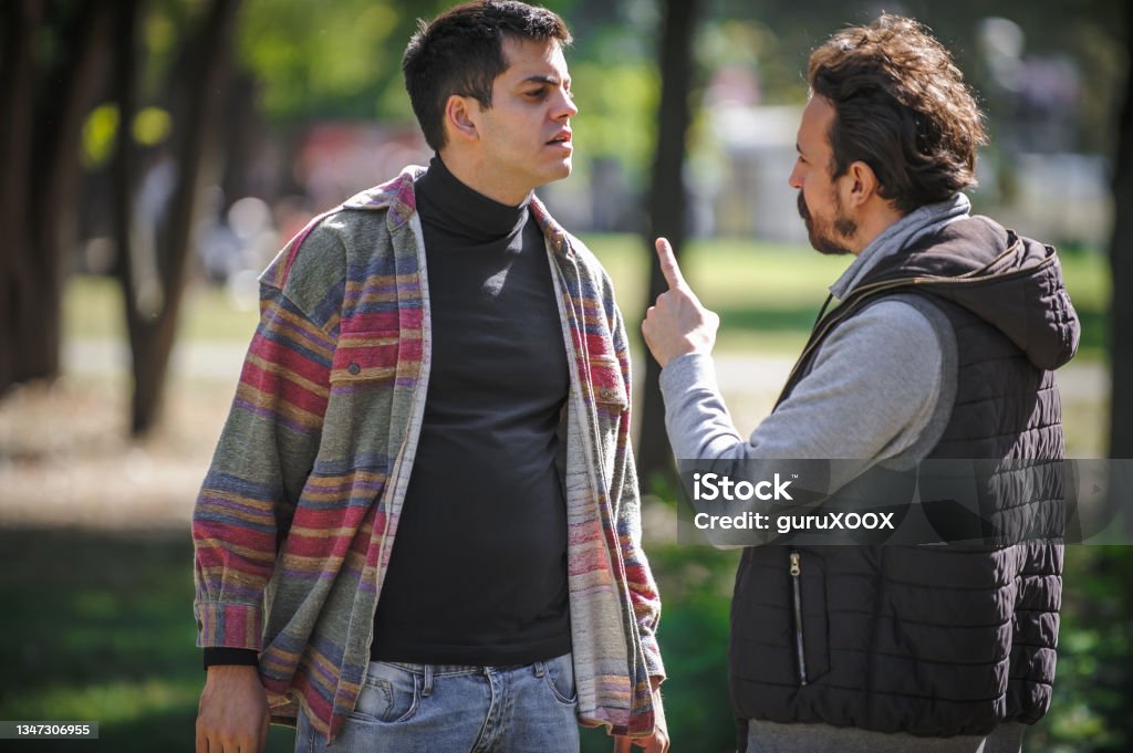Close-up finger pointing of two very angry men in conflict Close-up finger pointing of two very angry, nervous and upset men in an aggressive and fierce quarrel conflict on the verge of a physical confrontation and a fight. Concept of male conflict Men Stock Photo