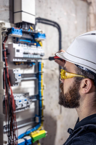 istock A male electrician works in a switchboard with an electrical connecting cable. 1347307602