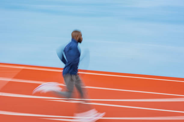 istock Young male athlete running on race track 1347309408