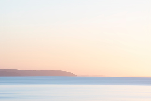 Stunning sunrise over Pentewan Sands in Cornwall with vibrant sky and long exposure ocean