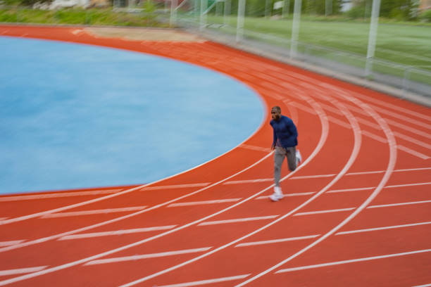 istock Young male athlete running on race track 1347312235