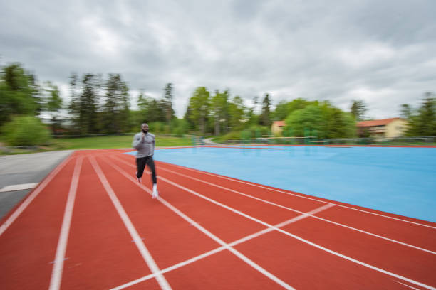 istock Young male athlete running on race track 1347312470