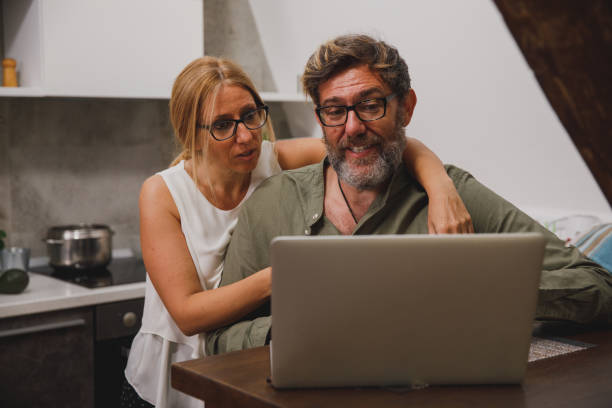 istock Mature couple surfing the net, choosing a dinner recipe 1347313439