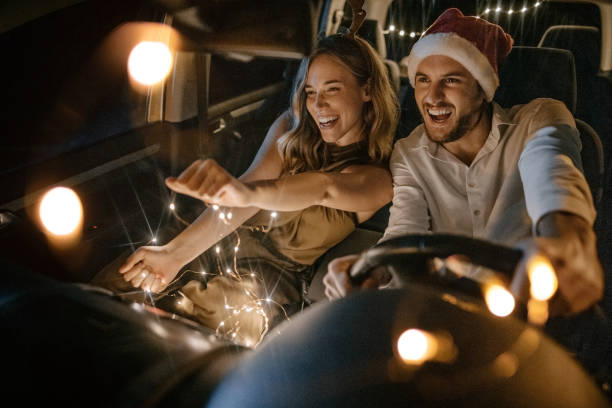Our little New Year's party in the car Photo of young couple having fun during the celebrating New Year in the car. couple driving at night stock pictures, royalty-free photos & images