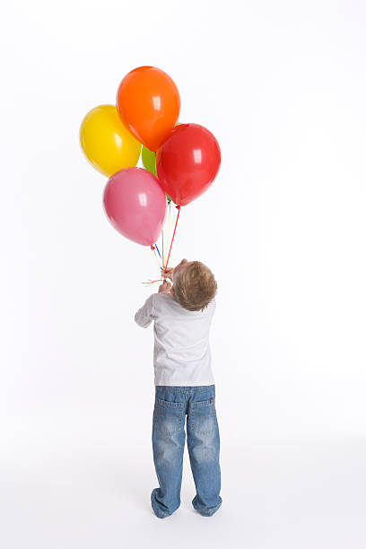 istock Little boy looking at his colored balloons 134731370