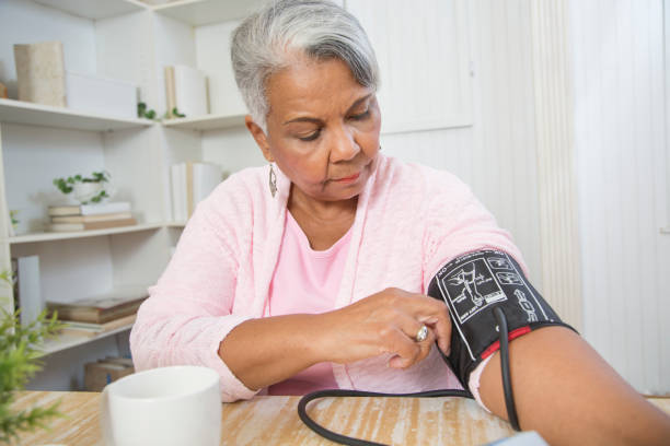 lovely senior african american woman monitors her blood pressure. - blodtryck orolig bildbanksfoton och bilder