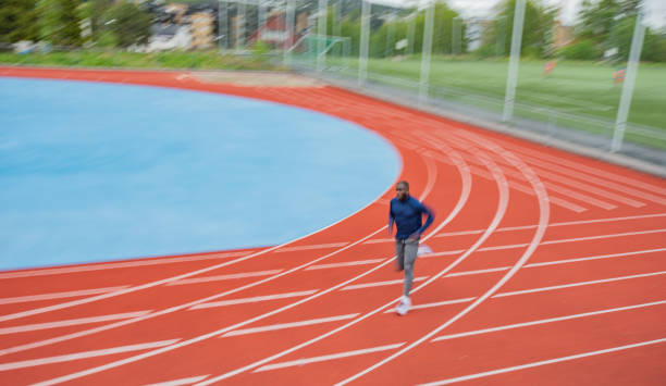 istock Young male athlete running on race track 1347316150