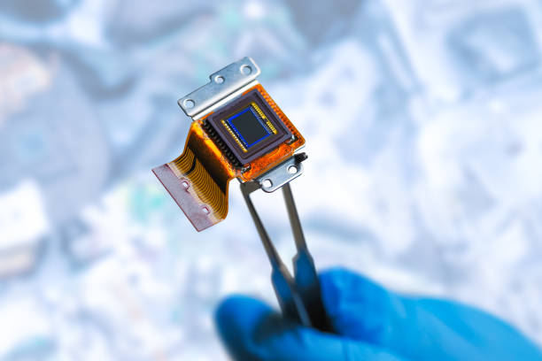 istock Man holding CCD sensor with tweezers, blue gloves. Silicon CCD matrix in the science lab. CCD sensor of a digital camera 1347316856