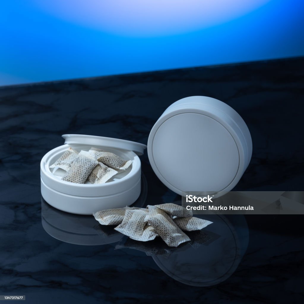 Closeup of a white swedish snus can and portion snuff pouches. Helsinki / Finland - OCTOBER 18, 2021: Closeup of a white swedish snus can and portion snuff pouches. Swedish Culture Stock Photo