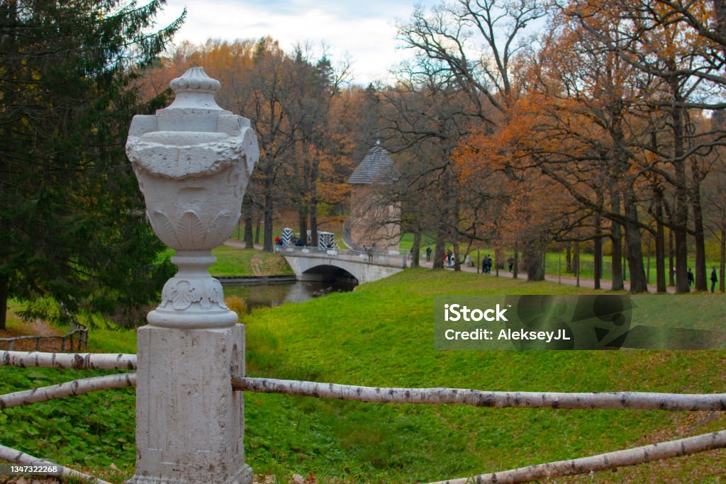An old flowerpot with a tower and a bridge in the background. Autumn Park. An old flowerpot with a tower and a bridge in the background. Autumn Park. Horizontal frame. Autumn Stock Photo