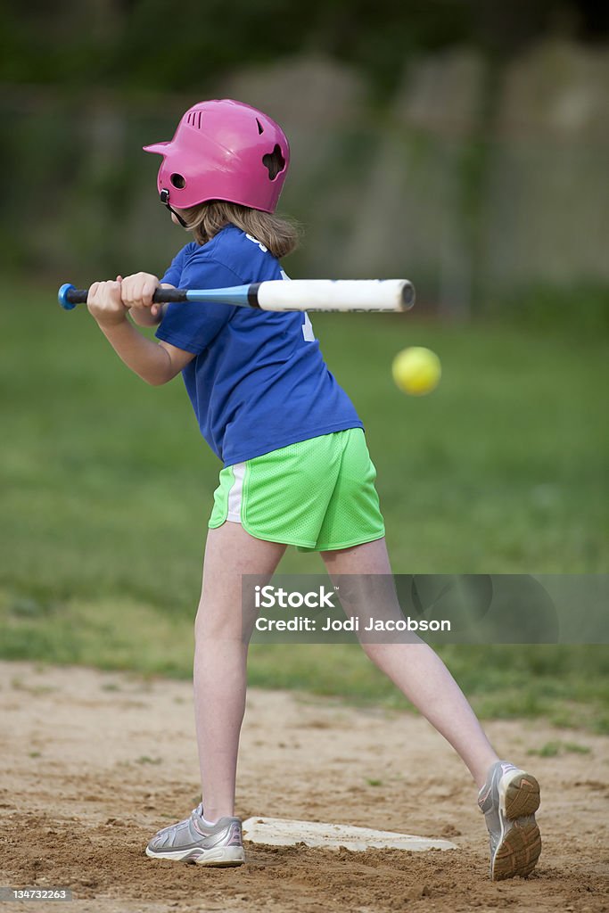 Fille de softball - Photo de Frapper avec une batte libre de droits