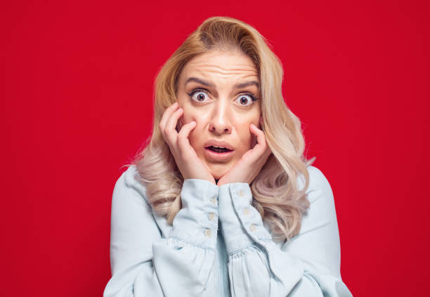 Mistake. Frightened young woman stare to you, isolated on white background stock photo