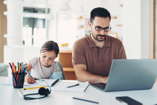 istock Young man working at home, his daughter sitting next to him and drawing 1347324544