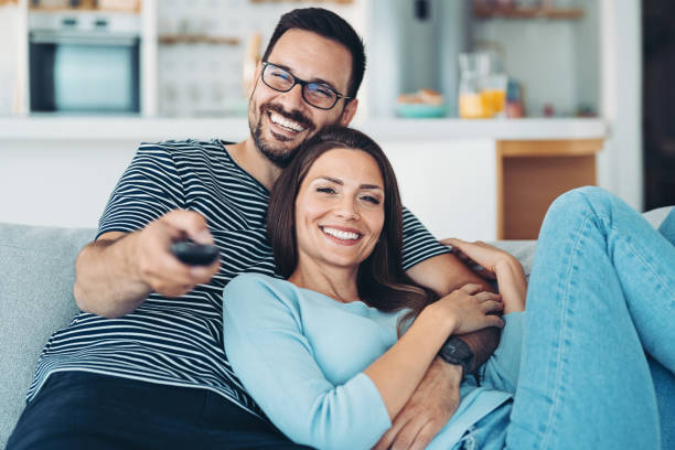 istock Smiling couple watching TV on the couch 1347324549