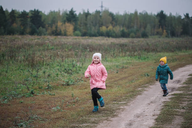 istock Children play in the field running from flying drone 1347324965