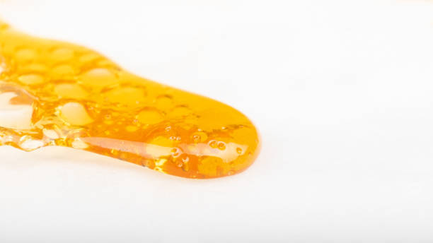 istock spreading drop of gold cannabis concentrate, wax with a high content of THC isolate 1347326847