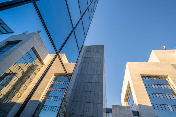 istock Looking up at glass and marble buildings with reflections 1347329016