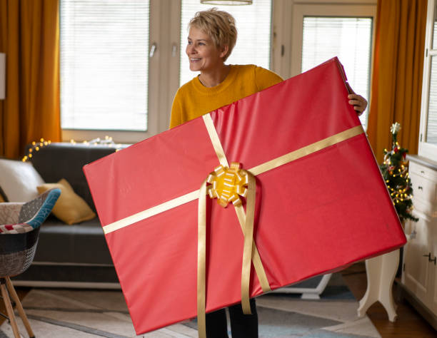 istock Woman is holding a huge Christmas gift 1347331190