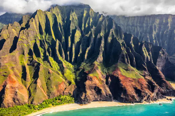 Photo of Hawaii beach, Kauai. Na pali coast view from helicopter. Hawaiian travel destinaton. Napali coastline in Kaui, Hawaii, USA. Aerial of Honopu arch