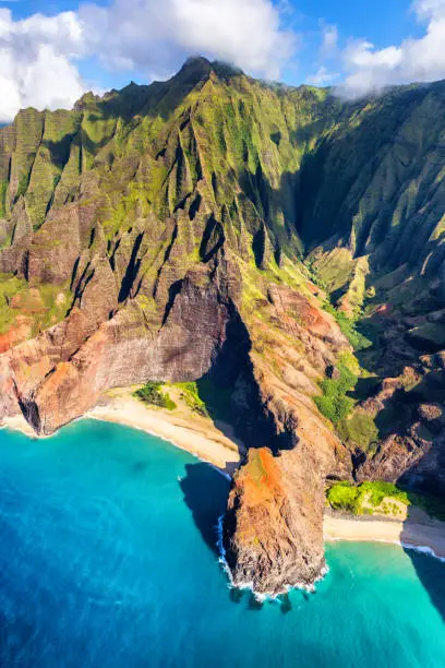 Photo of Hawaii beach, Kauai. Na pali coast view from helicopter. Hawaiian travel destinaton. Napali coastline in Kaui, Hawaii, USA. Aerial of Honopu arch