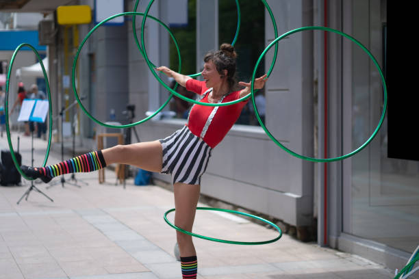 un artista callejero girando aros en la calle - acróbata circo fotografías e imágenes de stock