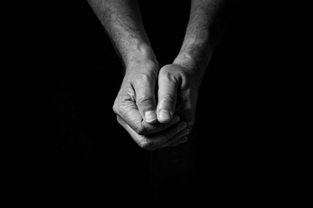 istock Male hands held out, clasped together in thought or prayer. 1347333892