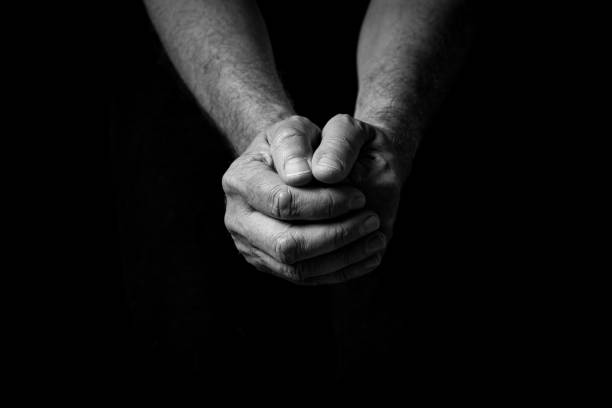 istock Male hands held out, clasped together in thought or prayer. 1347333905