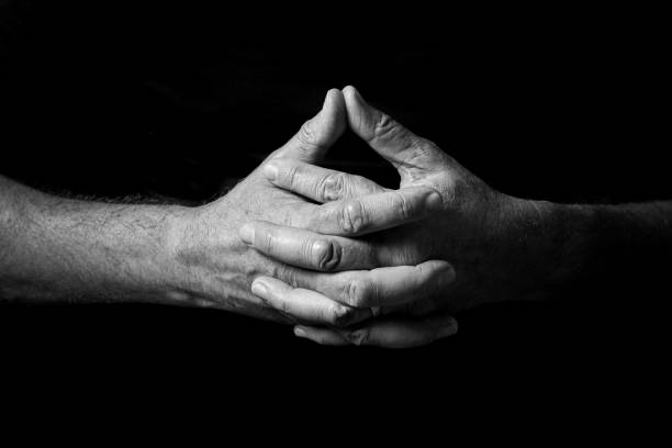 istock Male hands held out, clasped together in thought or prayer. 1347333961