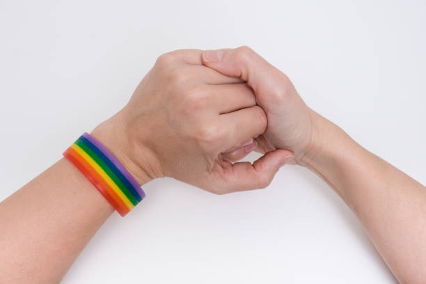 istock Hands wearing lgbt rainbow braselet on white background, pride month concept 1347334104