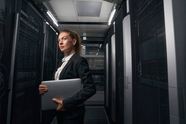 istock Young engineer businesswoman in network server room 1347338277