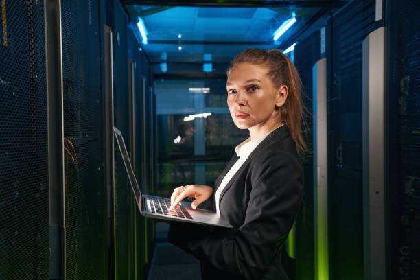 istock Determined woman with laptop working with servers in data center 1347338296