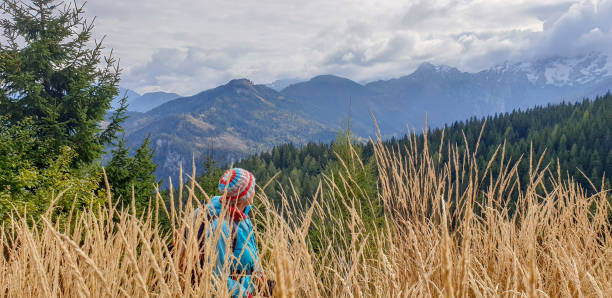istock Mature women behind high dry grass in mountains 1347338671