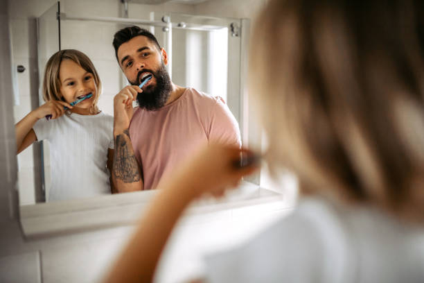 istock Father and daughter brushing teeth 1347342831