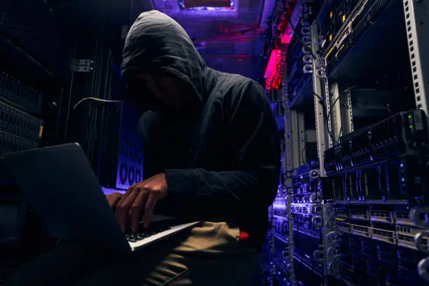 Expert cybercriminal gaining illegal access to computer network in data center