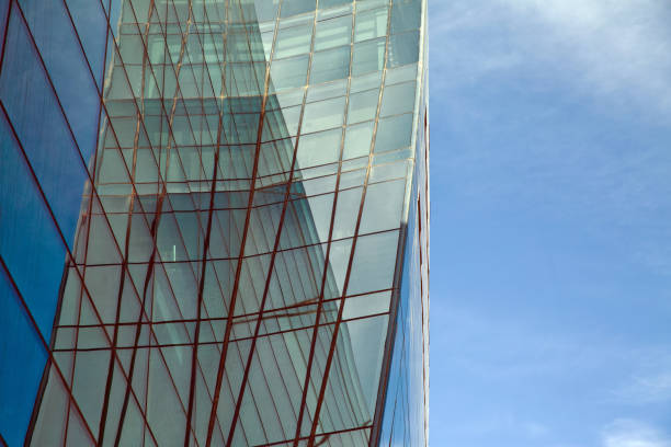 istock Perspective and underside angle view to textured background of modern glass building skyscrapers over blue cloudy sky 1347348027