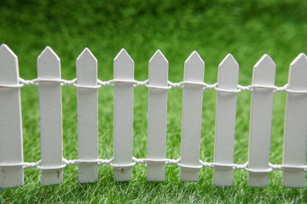 istock white fence and green grass, close-up 1347355099