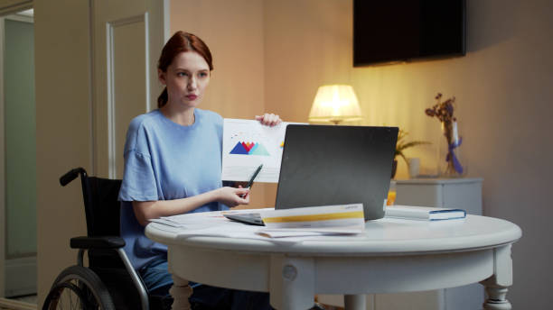 istock A disabled young woman is talking with someone and showing diagrams 1347357703